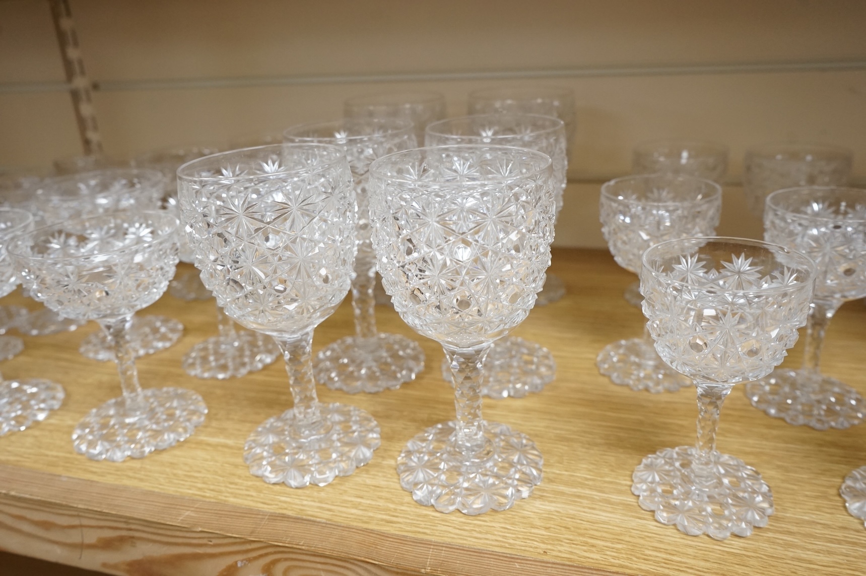 A Victorian heavy hobnail and star cut suite of table glass to include champagnes glasses and two decanters, largest 29cm high